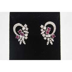 This is part of Chairish’s Fine Jewelry assortment.  Elegant 1950s diamond and ruby earrings with a semi circle diamond ribbon that leads to a ruby and diamond spray.  These earrings sit beautifully on the ear and can be worn with the circle next to the ear or with the spray next to the ear which creates 2 different looks.  They have a post as well as a lever back. They are 18k white gold and contain approximately 1.12 carats in rubies and 3.08 carats in diamonds. Exquisite Ruby Earrings In White Gold, Ruby Brilliant Cut Fine Jewelry Earrings, Gold Ruby Earrings With Diamond Accents, Elegant Round Ruby Diamond Earrings, Red Ruby Earrings With Diamond Accents, Diamond Ribbon, Circle Diamond, Ruby Earrings, White Gold Earrings