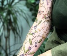 a woman is holding her arm with flowers on it