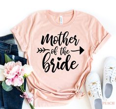 a t - shirt that says mother of the bride with an arrow on it next to flowers