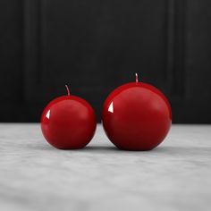 two red apples sitting next to each other on a table