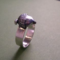 "From little things can GIANTS grow!! You get the idea! The acorn on this piece has been cast, and then silver soldered to its fabricated shank. The finish is brushed ,with a slight antiquing. The shank, or band measures about 5mm, or just under 1/4\". It is a potentially inspiring ring! This piece can also be done in a high polish if desired. Made to order." Survive Divorce, Silversmithing Jewelry, Silver Oak, Tree Ring, Tree Rings, Oak Tree, Ring Silver, Rings Statement, Little Things