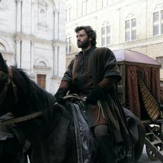 a man sitting on top of a black horse