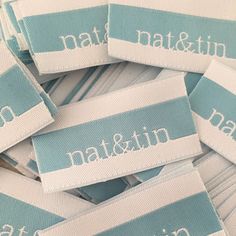 blue and white name tags are stacked on top of each other, with the word nat & ni written across them