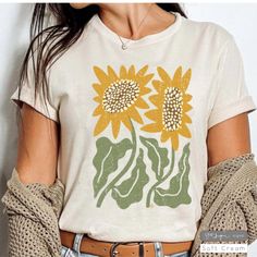 Description: Our "Boho Sunflower" design on Bella Canvas cotton Unisex T-shirt.  The American graphic tee shirt is an icon of individuality around the world. Who doesn't love a good t-shirt day? It means you get to feel comfortable wherever you're headed, while also showing off your style and personality!  Feel confident you are purchasing a quality product that is eco-friendly and produced in America. Our DTG printing is eco-friendly utilizing water based inks! Our shirt manufacturer, Bella+Canvas, is committed to a full eco-friendly manufacturing process. Their tee has a soft and light feel, with just the right amount of stretch. It's comfortable and the unisex cut is flattering for both men and women. Well-constructed, long lasting, holds its color through wear and wash. We can't compli Boho Sunflower, Wildflower Shirt, Boho Tees, Botanical Shirt, Graphic Tee Shirt, Sunflower Design, Dtg Printing, Retro Floral, Graphic Tee Shirts