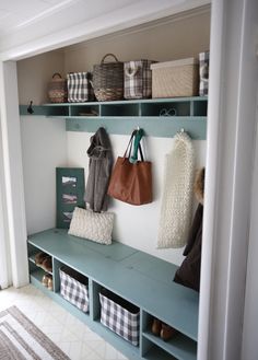 a coat rack with several coats and purses hanging on it's sides next to a bench