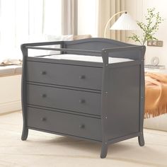 a baby crib with drawers in a room