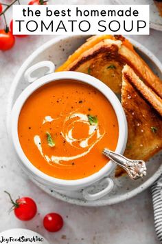 a bowl of tomato soup with grilled bread on the side and tomatoes in the background