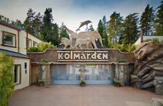 the entrance to kolmarken with statues of animals and trees in the background