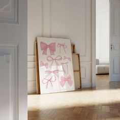 an empty room with white walls and pink bows on the wall, framed in wood