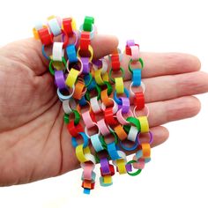 a hand holding colorful bracelets in it's palm