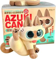 a stuffed toy cat sitting in front of a box with the caption azzuni can