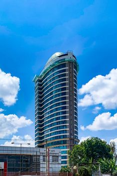 a tall building sitting next to a lush green park