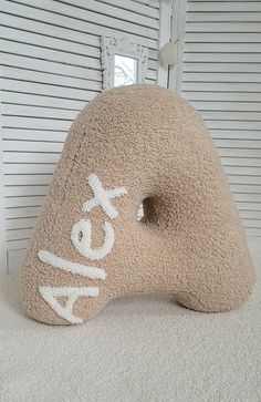 a stuffed animal with the word relax on it's face sitting in front of a window