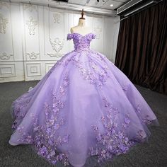 This Romantic Quinceanera Dress is the epitome of timeless elegance and dramatic flair. Its stunning ball gown silhouette is made from luxurious lace fabric that adds both texture and romance. The dress features a breathtaking off-the-shoulder neckline, adding a touch of sophistication to the sleeveless design. Its delicate 3D flower appliques gracefully embellish the bodice and flow down into the voluminous skirt, creating a captivating visual effect. The cathedral train ensures a grand entranc Purple Ballgown, Lilac Quinceanera Dresses, Lavender Quinceanera Dresses, Lavender Quinceanera, Purple Ball Gown, Purple Quince, Purple Quinceanera Dresses, Quinceanera Themes Dresses, Princess Evening Dress