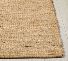 an area rug on the floor that is made from jute and has been woven into it