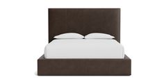 a bed with white pillows and brown leather headboard on top of it, in front of a white background