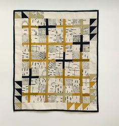 a black and white quilt hanging on a wall