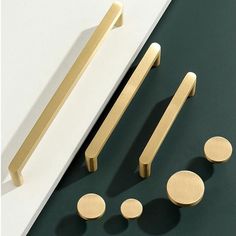 brass handles and knobs on a green surface