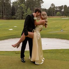 a man and woman kissing on the golf course