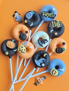 a bunch of doughnuts on sticks with halloween stickers in the top one