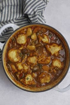 a pot filled with stew and potatoes on top of a table