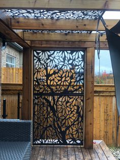 a wooden deck with an iron gate on the top and bottom part that has a tree cut out in it