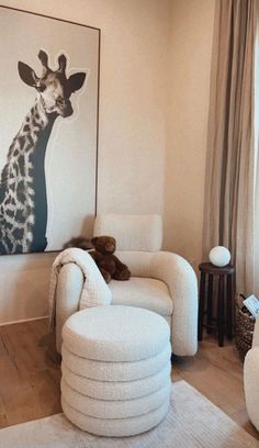 a living room filled with white furniture and a giraffe painting on the wall