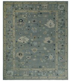 an area rug with various flowers and leaves on the bottom, in grey tones that are bordered by gold trimmings