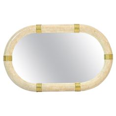 an oval mirror with bamboo trimmings on the edge and bottom, in white marble