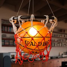 a basketball hanging from a light fixture in a room with other items on the table