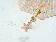 Starfish Belly Ring Show off your beautiful belly! Belly ring features a textured golden starfish charm with sparkly pink enamel accented with a hand wire wrapped pink agate bead. Belly button ring measures 1 3/4 inches long total length. Barbell is 14g gold plated surgical steel with a 10mm wearable bar length. For Belly Button Rings: https://www.etsy.com/shop/AllAboutClass?section_id=18474235&ref=shopsection_leftnav_1 For Industrial Barbells: https://www.etsy.com/shop/AllAboutClass?ref=l2- Amazon Belly Rings, Summer Belly Button Rings, Beachy Belly Button Piercing, Fun Belly Button Rings, Ocean Belly Button Rings, Pink Dangle Belly Rings As Gift, Starfish Belly Button Ring, Western Fashion Jewelry, Starfish Jewelry