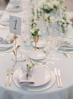 the table is set with white plates and silverware