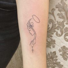 a woman's arm with a tattoo on it and a cross in the middle