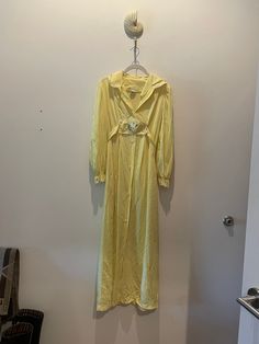 "Estate sale find. Very pretty nylon Dutchess Individually Yours yellow maxi dress.   It's a classic 1970's maxi dress with an attached sash with white rose detail that ties at back.  The vanity size label is a Small and would fit a size an x-small/ small best today.  Please review video, pixs, and measurements below.  All sales final. PTP 17\" STH 49\" *This is a vintage item which has history and was pre-loved. All major flaws are listed, but small blemishes like loose stitches and buttons may Yellow Maxi Dress, Yellow Maxi, Belt Tie, Boho Cottagecore, Rosé Details, Estate Sale Finds, Size Label, Belt Tying, White Rose