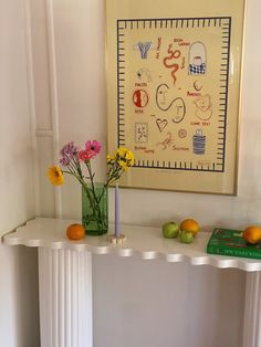 a white table topped with vases filled with flowers next to an orange and green book