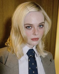 a woman with blonde hair wearing a suit and tie