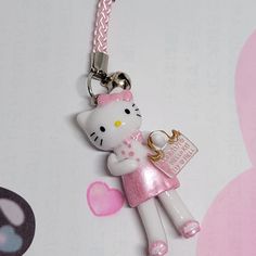 a hello kitty keychain with a pink bow on it's head and a tag attached to it