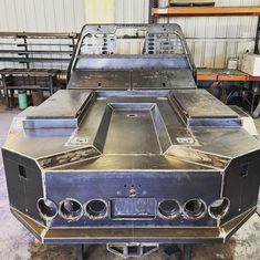 an old metal car is being worked on in a garage with other equipment around it