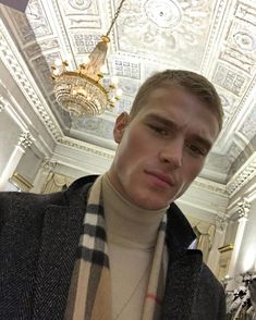 a young man is taking a selfie in a room with white walls and ceiling