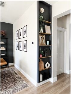 a black bookcase with pictures on it in a living room next to a door