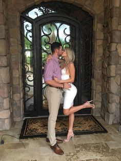 a man and woman kissing in front of a door