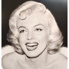 an old black and white photo of a woman with blonde hair smiling at the camera