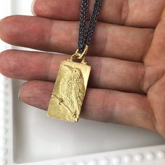 "This Raven pendant was hand carved in wax by Carrie who uses a microscope to create fine detail. It was then cast in 18k gold in her shop. The background has a soft satin finish while the high spots are polished to catch the light. It hangs on an 18\" Sterling Silver double chain that has a dark patina and is finished with an 18k Gold clasp. It measures 34mm x 14mm. Pendant weighs 14.35g." Carved Yellow Gold Amulet Jewelry, Luxury Carved Yellow Gold Necklaces, Artisan Engraved Yellow Gold Necklace, Luxury Carved Gold Necklace, Luxury Carved Gold Jewelry, Luxury Etched Yellow Gold Jewelry, Carved Yellow Gold Necklace, Carved Yellow Gold Necklace For Gift, Carved Yellow Gold Necklace Perfect For Gift