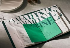 an open book sitting on top of a table next to plates and utensils