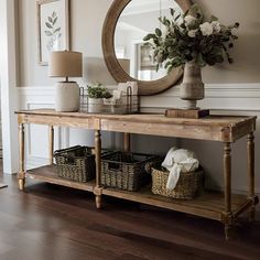 a wooden table topped with baskets under a mirror