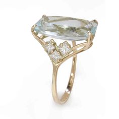 a gold ring with an aqua blue topazte and white diamonds on it's sides