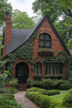 a brick house with ivy growing all over it's walls and windows, along with a walkway leading to the front door