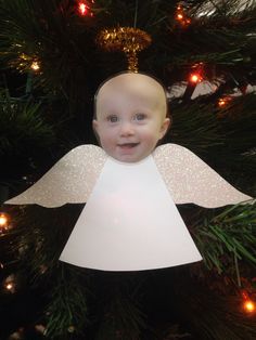 an angel ornament hanging from a christmas tree