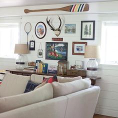 a living room filled with lots of furniture and pictures on the wall above it's couches