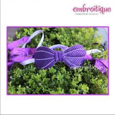 a purple bow on top of some green plants